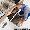 A man installing a new integrated dishwasher